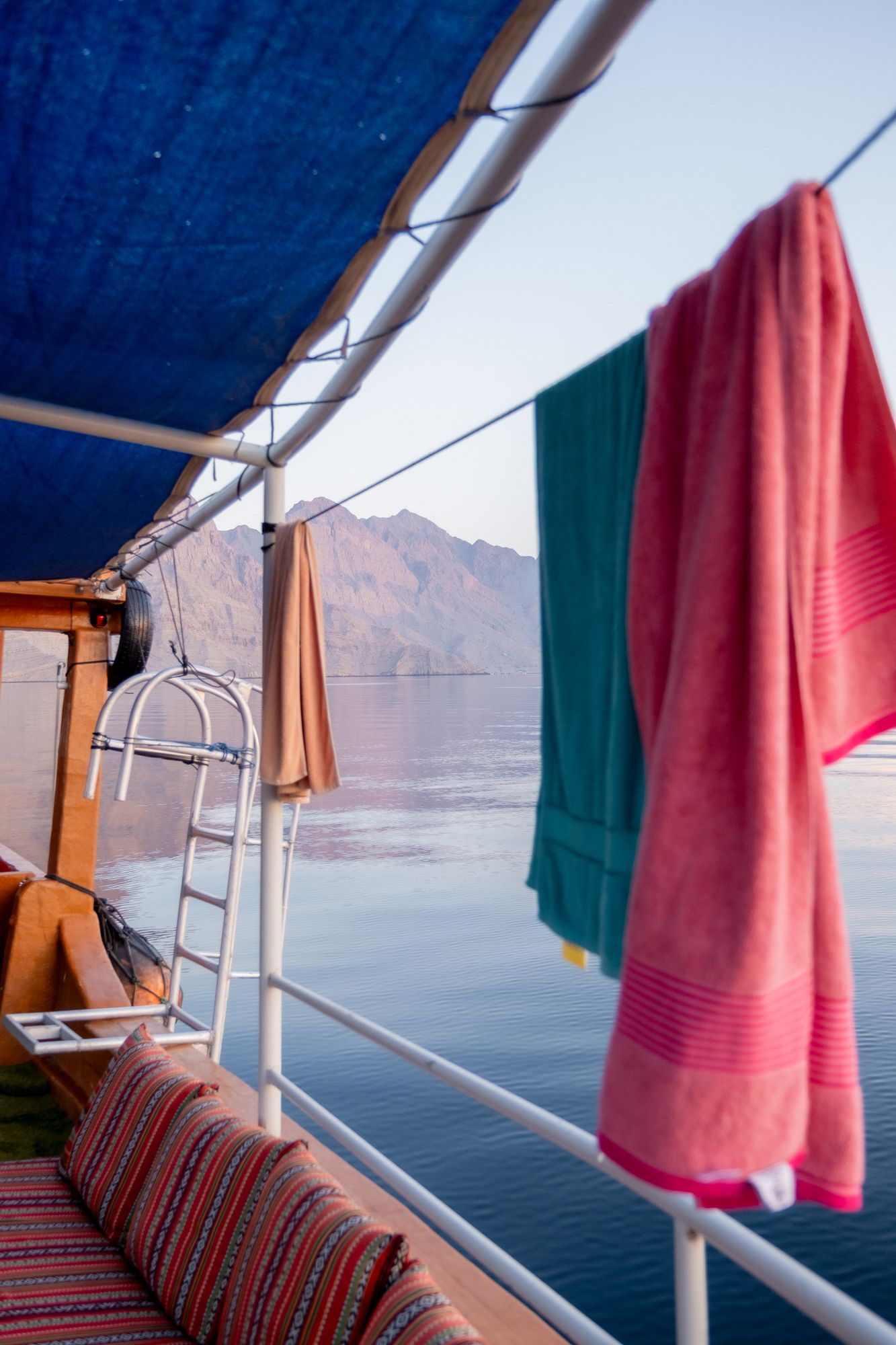 Towels drying on a boat deck above a calm bay