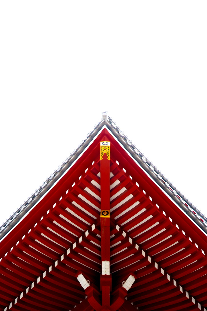 Red temple roof beams rising into a white sky